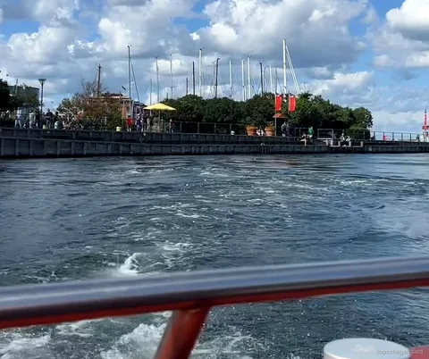 Barco del Crucero por los Canales de Copenhague saliendo de Ved Stranden junto a edificios históricos