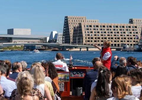 Guide fortæller om ruten for København Kanalrundfart nær Den Lille Havfrue
